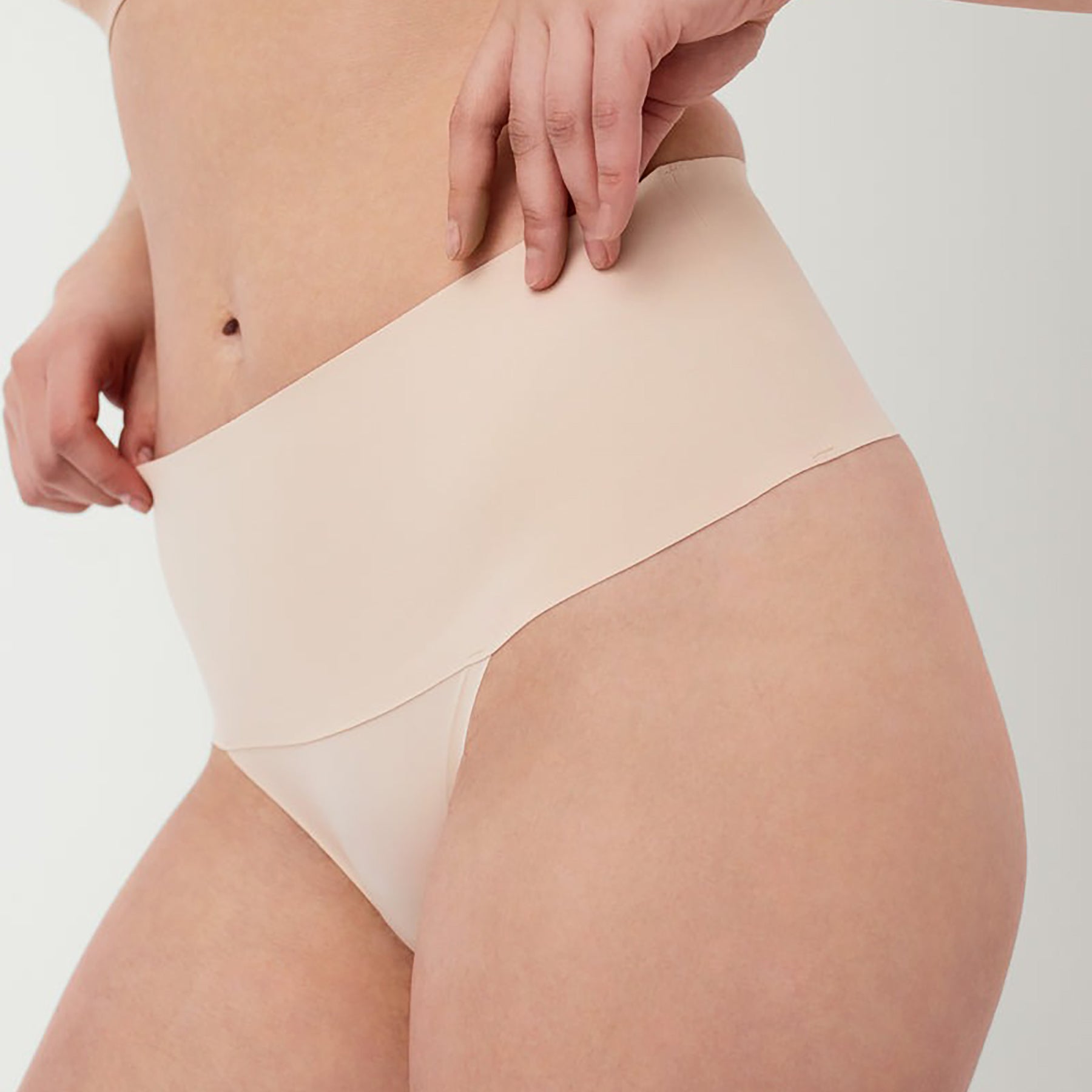 Close-up front view of SPANX High-Waist Seamless Thong in Soft Nude, featuring smooth compression fabric and invisible edges.