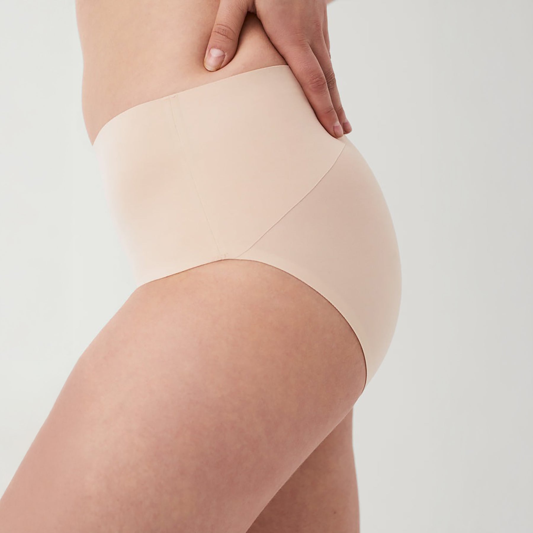 Side view of SPANX Soft Nude seamless shaping brief highlighting high-rise waistband for tummy control and all-day comfort.
