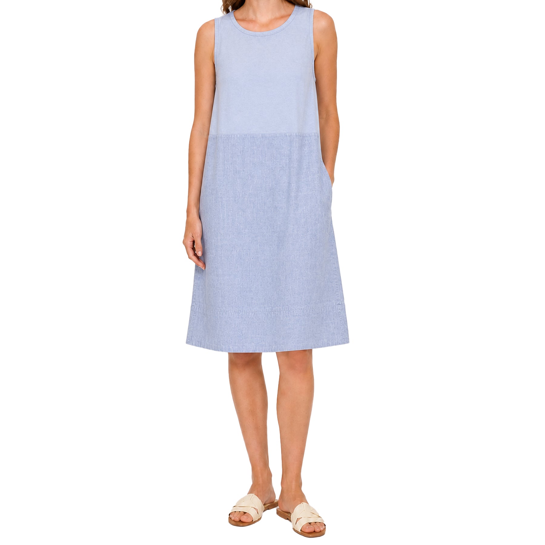 Light blue sleeveless A-line dress on a model, showcasing a clean neckline, easy fit, and gently flared skirt for an effortless everyday look.