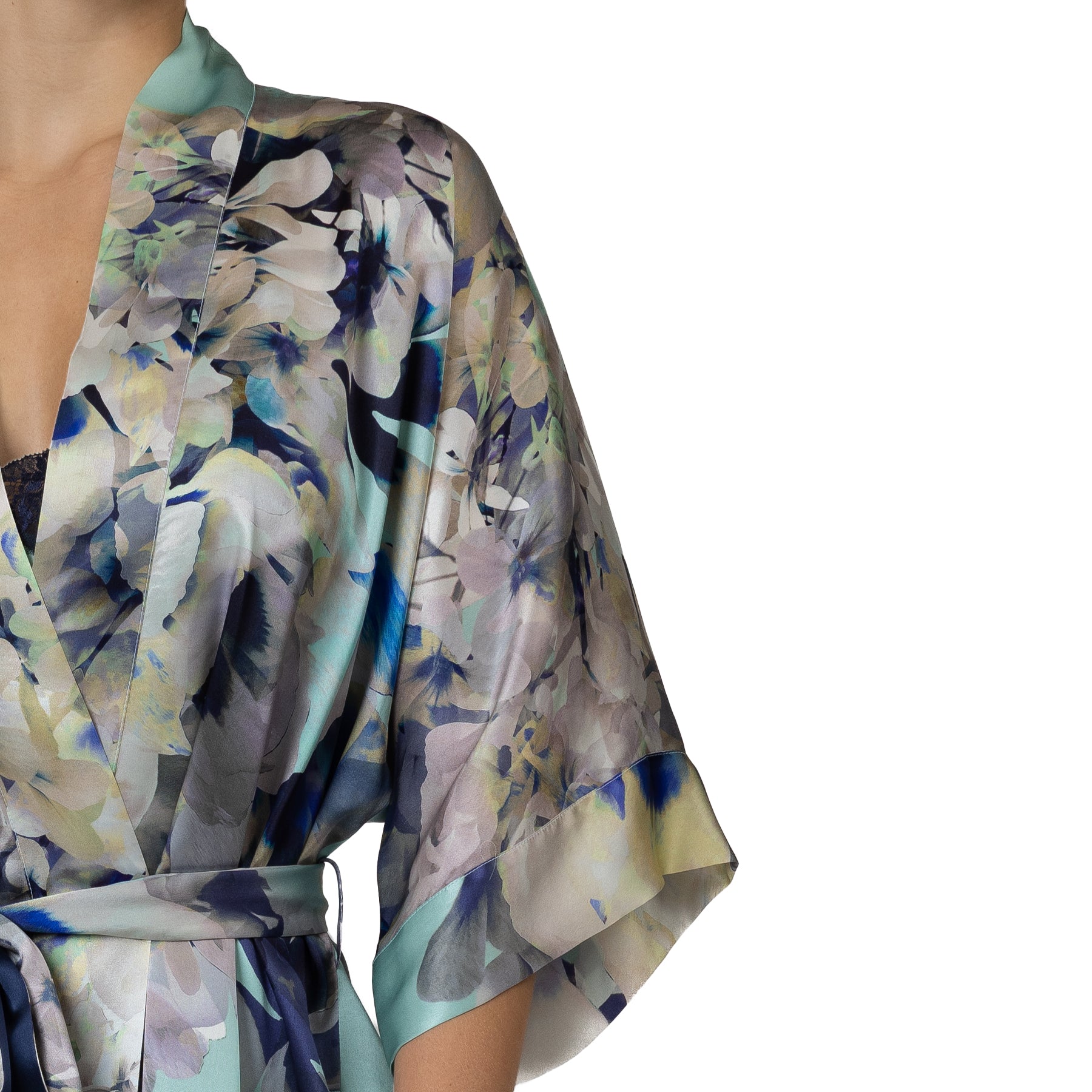 Close-up of a silky floral robe featuring flowing kimono sleeves and a soft pastel floral print with blue accents.