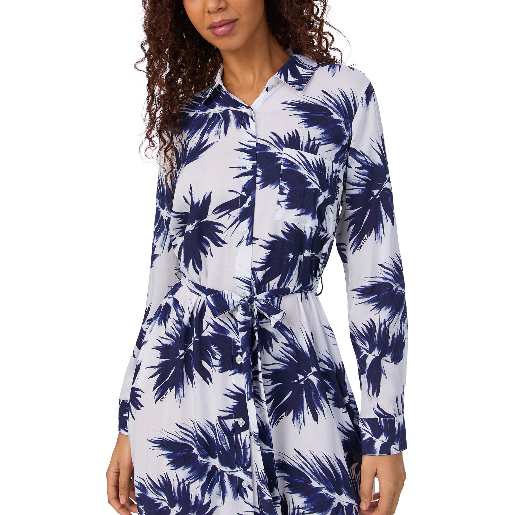 Close-up of buttoned front and belted waist on a navy palm-print shirt dress with chest pocket.