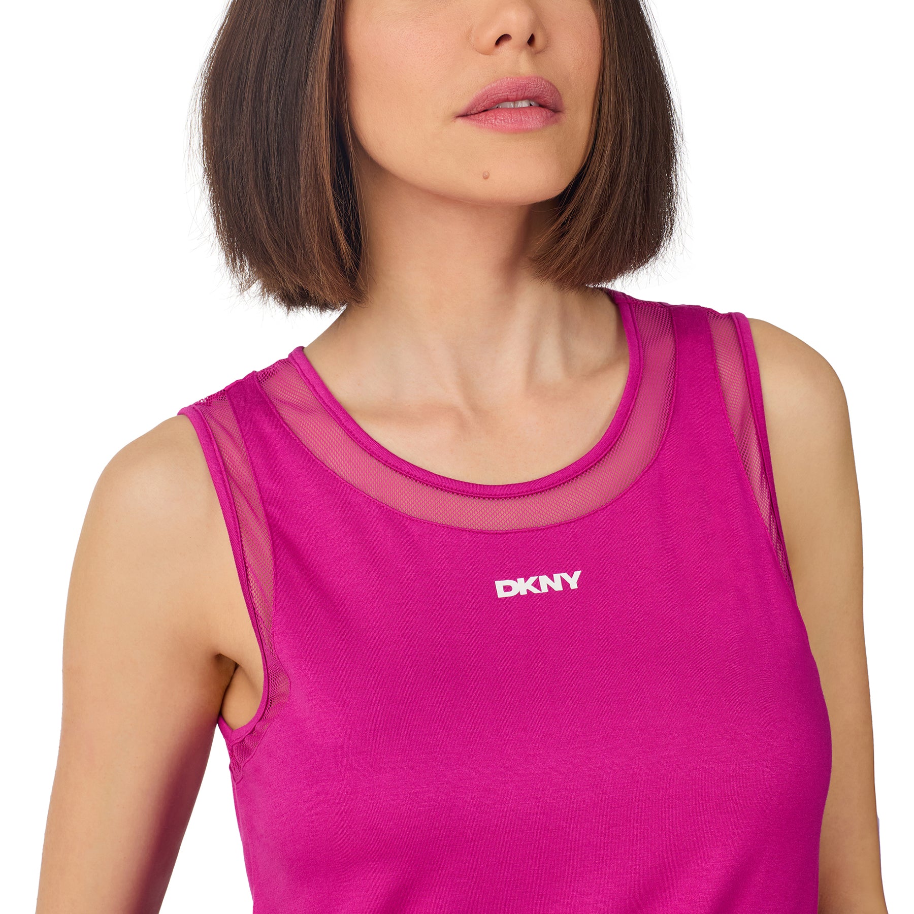 Woman wearing a bright fuchsia DKNY sleeveless lounge top with mesh neckline and matching shorts