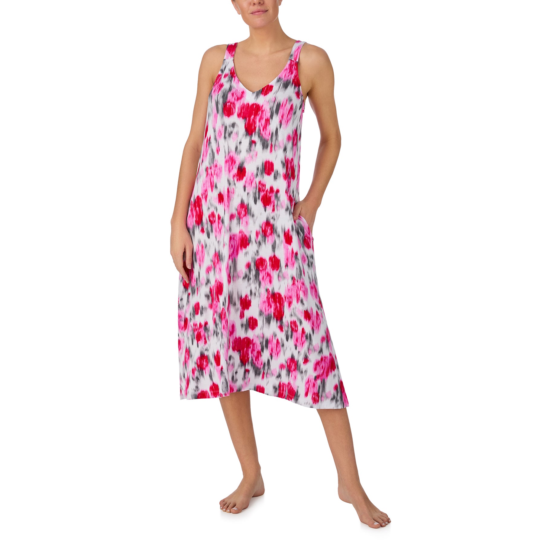 Woman wearing a sleeveless pink and grey floral sleep dress with a relaxed silhouette, side pockets, and flowing midi length.