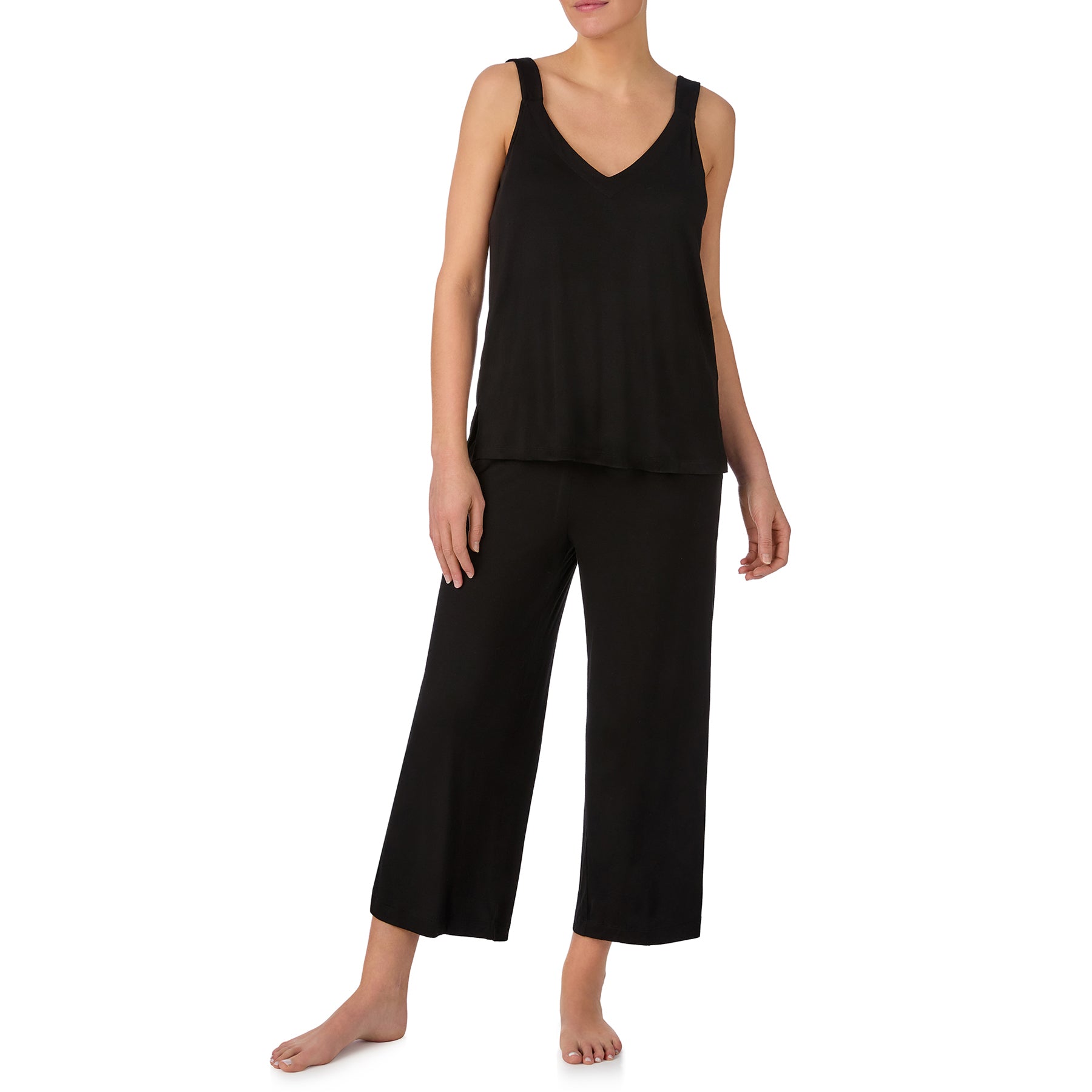 Woman wearing a soft black sleeveless pyjama set with a flowy V-neck tank top and comfortable cropped lounge pants.