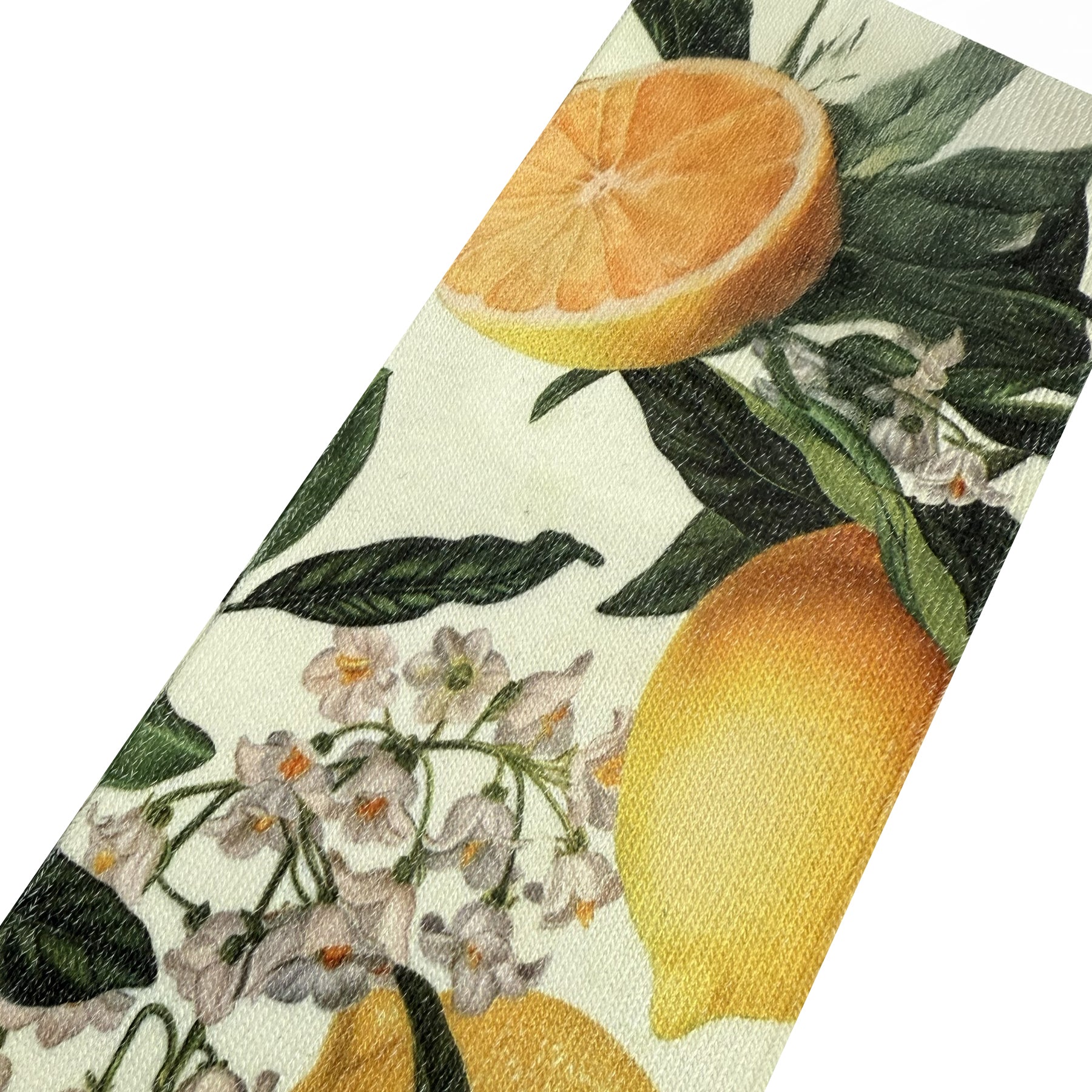 Close-up of lemon and orange slice print on XP000S crew socks featuring botanical leaves and delicate white flowers on cream background.