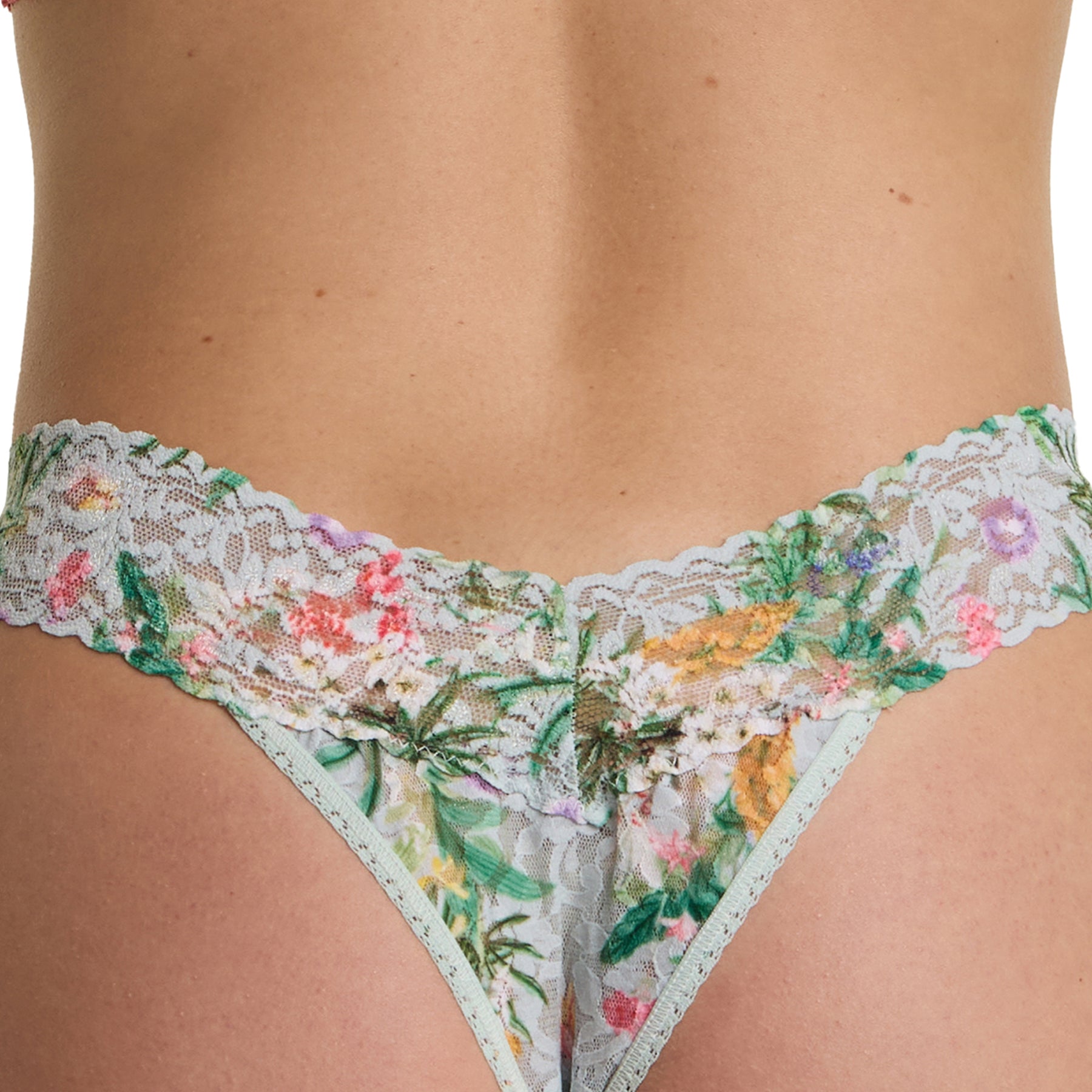 Close-up front detail of the floral lace thong showing the scalloped lace waistband and fine botanical pattern.