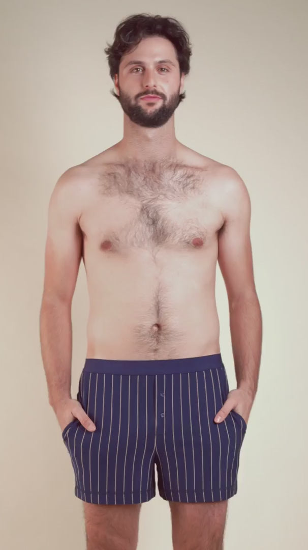 Motion view of men’s striped pyjama boxers featuring button fly and modern lounge design.