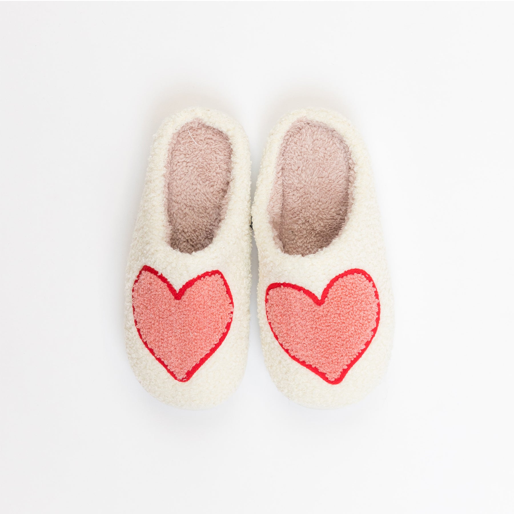 Cozy cream women’s slippers with large red heart design on the front.