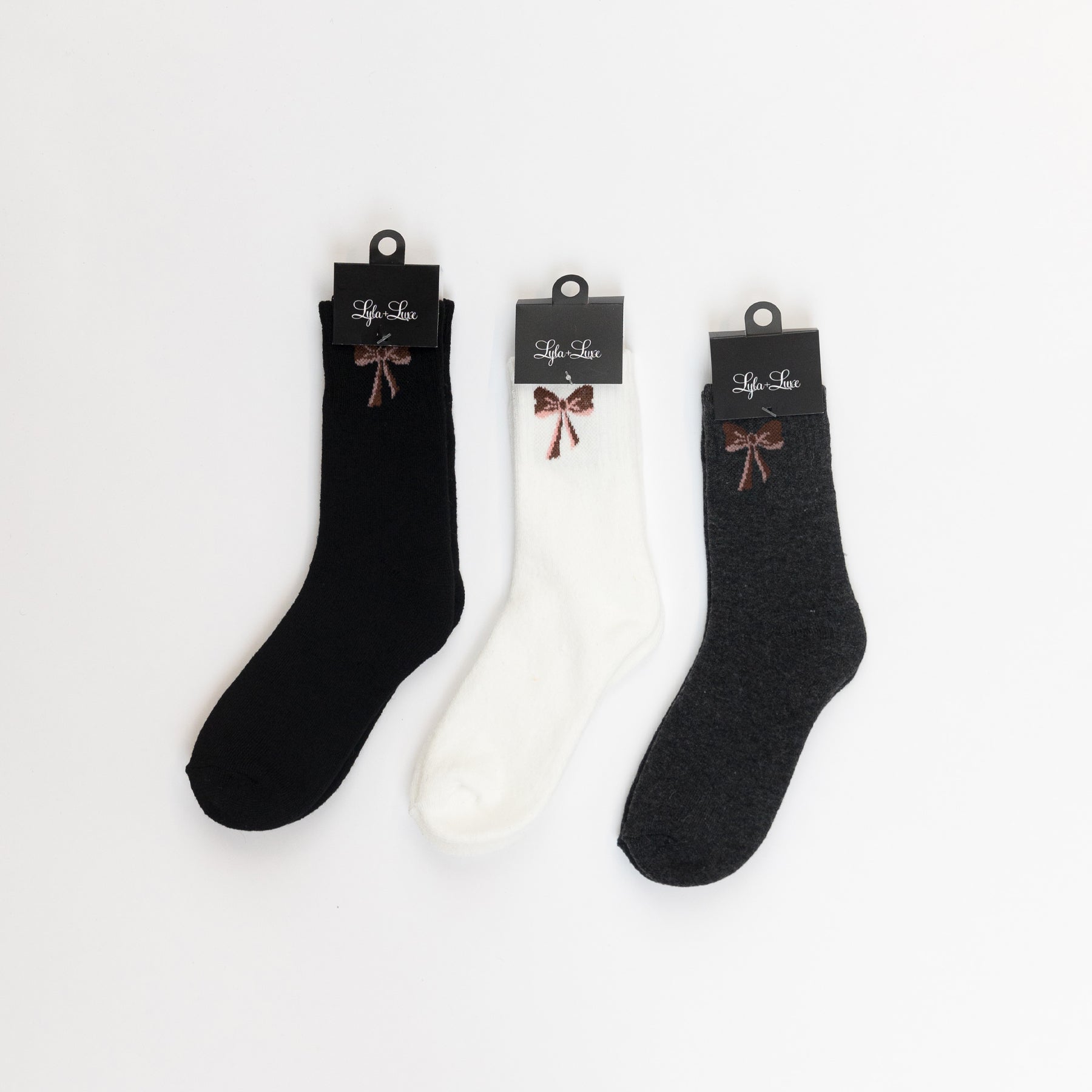 Set of three women’s crew socks in black, white, and dark grey with small bow design near the cuff.