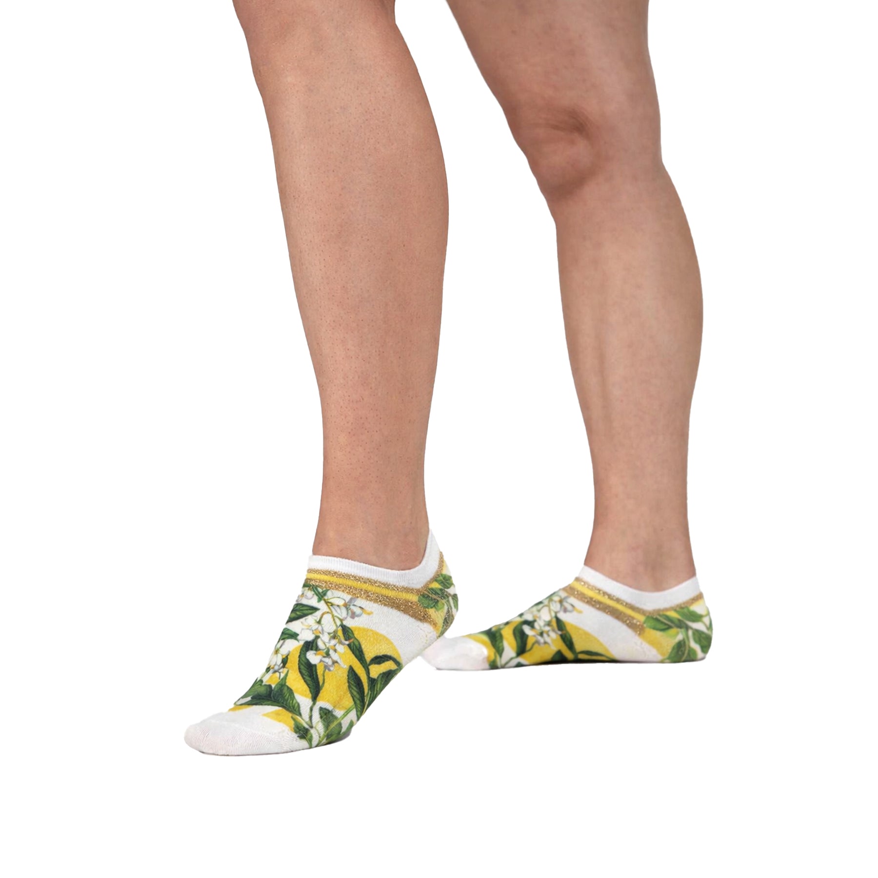 Model wearing lemon and floral print low-cut socks with yellow citrus pattern, green leaves and gold stripe detail at the cuff.