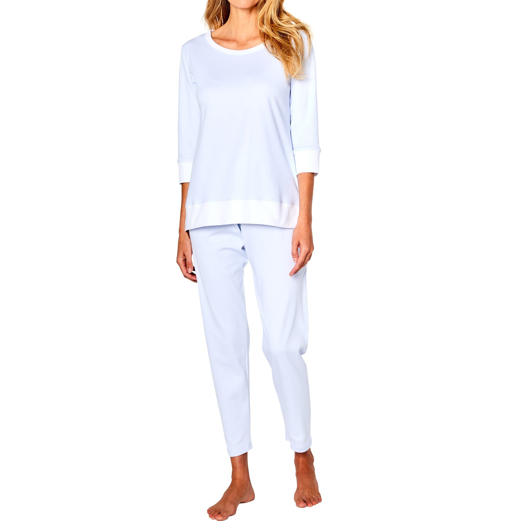 Woman wearing a white long-sleeve top and pants on a white background