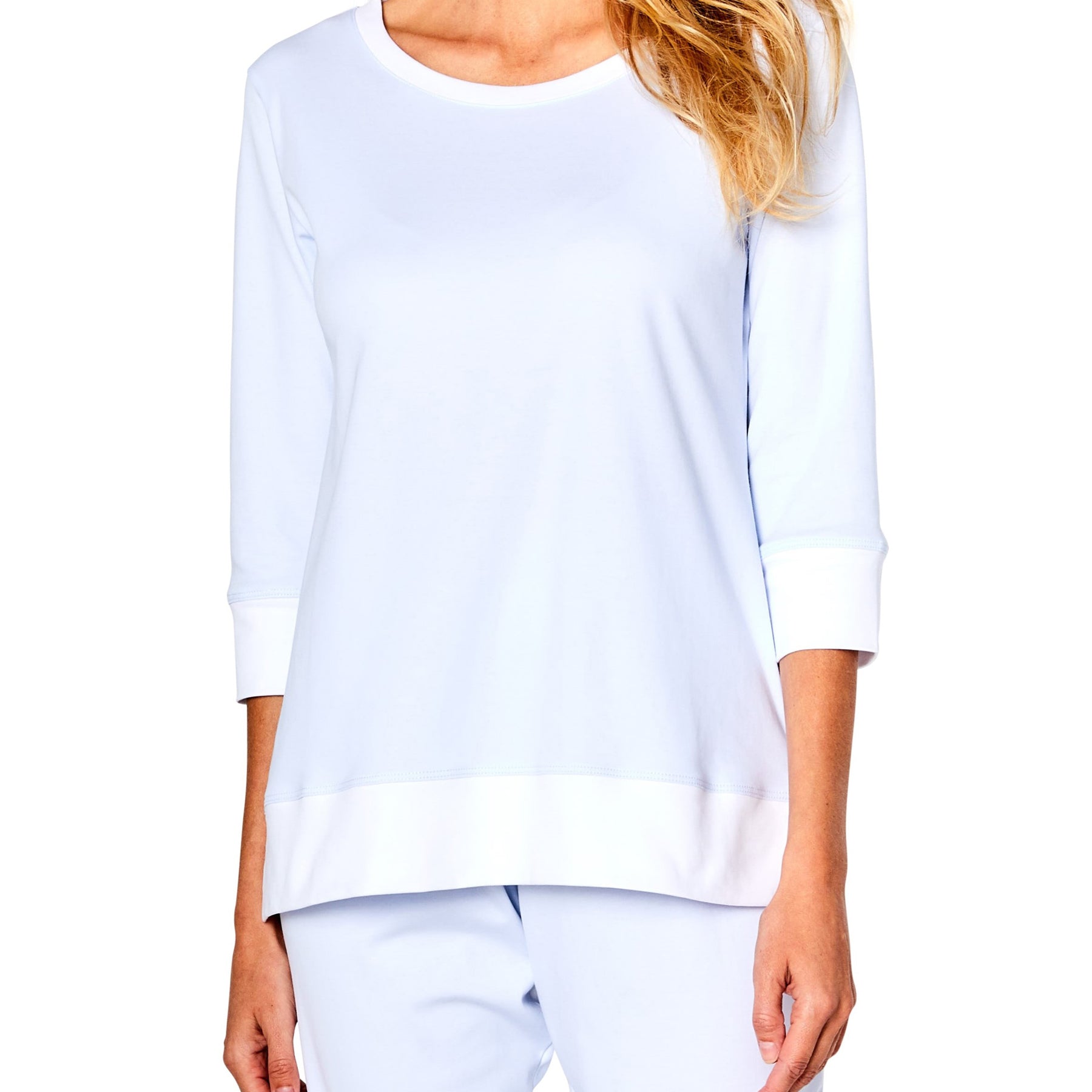 Woman wearing a white long-sleeve top and pants on a white background